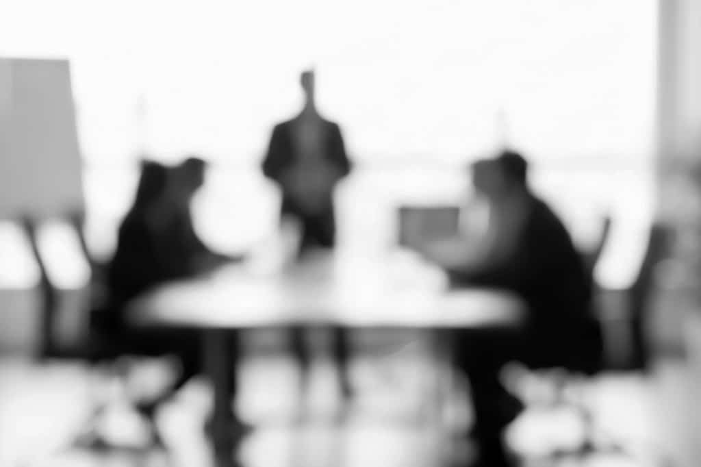 Blurred black-and-white business learning scene, representing Agile Business Consortium learning