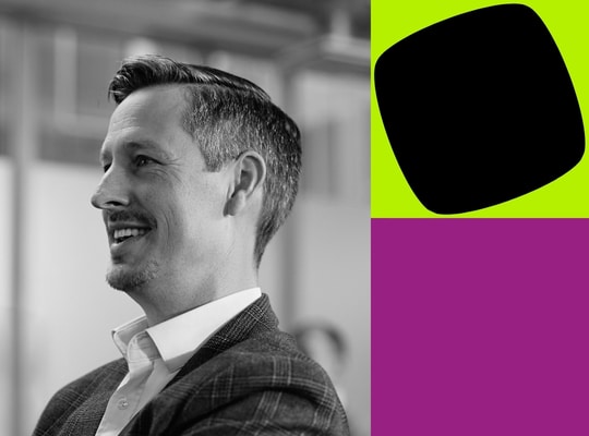 Black-and-white portrait of a smiling professional beside bold green and purple graphic blocks, representing Agile Business Consortium membership